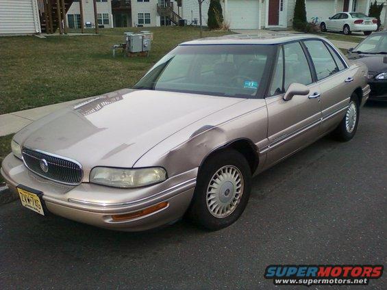 Tan sedan with dented front fender and chrome grille