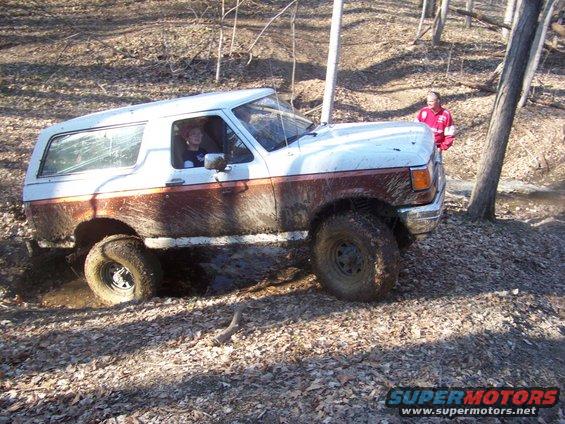 1989 Ford Bronco stuck in mud with driver visible