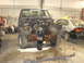 1993 Ford F-150 - A disassembled truck sits in a garage next to another car, awaiting repairs.