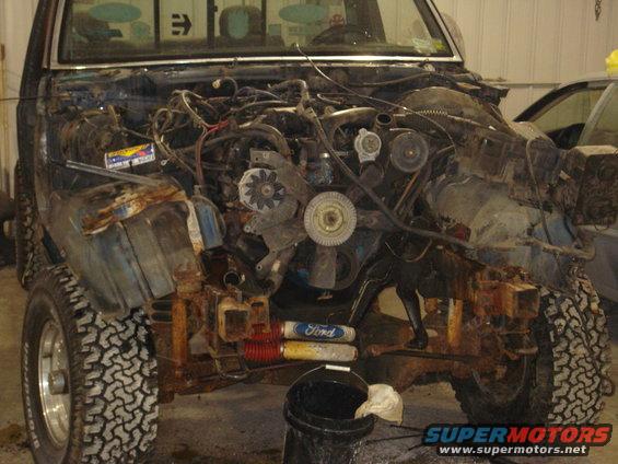 1993 Ford F-150 front end with engine removed, showing rusted chassis and off-road tires