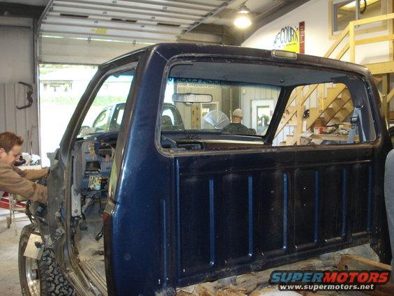 Blue 1993 Ford F-150 cab undergoing repairs, side view