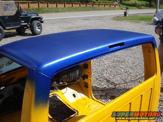 1993 Ford F-150 truck cab with blue roof and yellow body, parked next to a Jeep Wrangler