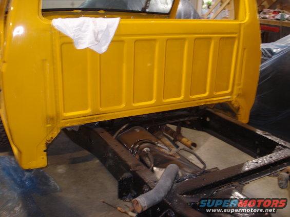Yellow 1993 Ford F-150 cab rear section and frame during restoration
