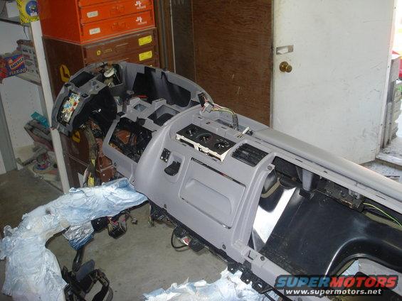 Gray dashboard assembly with exposed wiring and vents