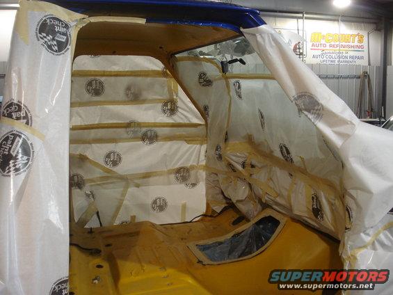 Interior of a vehicle covered in protective sheeting for painting