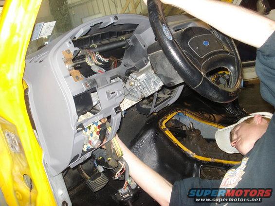 Dashboard and steering wheel of a vehicle being worked on, with exposed wiring and parts