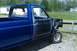 1993 Ford F-150 - This blue pickup truck is missing its front end and has primer on the driver's door.