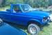 1993 Ford F-150 - This blue 1993 Ford F-150 pickup truck is seen from a 3/4 front angle, parked outdoors.