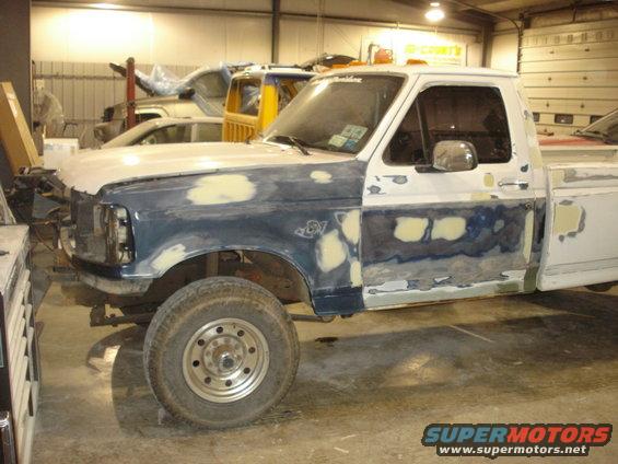Truck bodywork in progress, primer and filler visible on doors and fenders