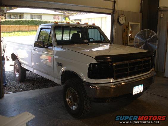 White 1993 Ford F-150 truck, 3q-front view. Harley-Davidson decal on windshield
