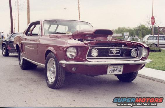 Maroon 1967 Ford Mustang with a large hood scoop and custom wheels