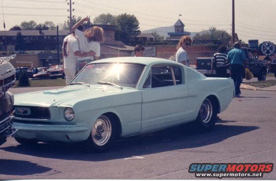 Light blue 1965 Ford Mustang coupe with racing roll cage and aftermarket wheels