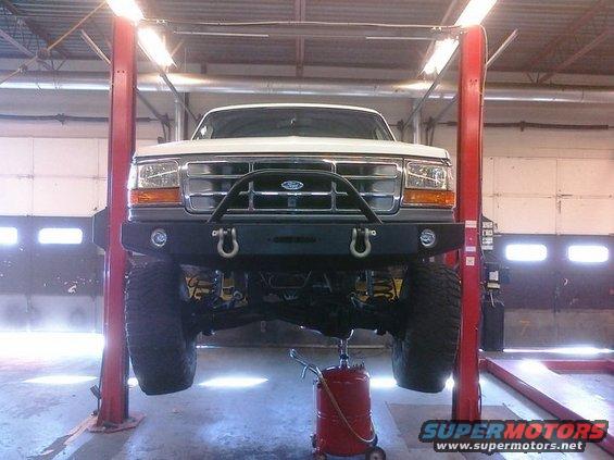White 1995 Ford Bronco front view on lift with aftermarket bumper
