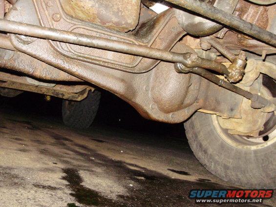 Undercarriage view of rusty steering linkage and front axle assembly