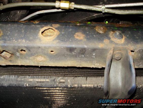 rusted metal frame rail above a vehicle's radiator
