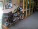 2001 BMW R1150GS ABS - A vintage motorcycle with a green gas tank and black seat is displayed indoors, with memorabilia on the wall.