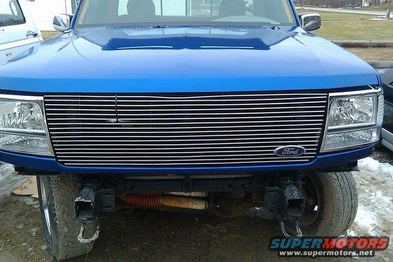 Front view of a blue 1992 Ford F-150 with a chrome grille and aftermarket tow hooks