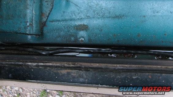 Teal door frame with water pooling in the seal. 1992 Ford Bronco