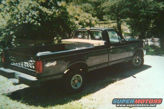 Black 1992 Ford F-150 pickup truck with a toolbox in the bed, parked outdoors