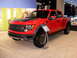 2011 Ford F-150 - Red Ford F-150 Raptor pickup truck on display at an auto show.
