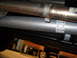2011 Ford F-150 - Close-up of vehicle exhaust pipes, one showing rust and the other a clean metal finish with part numbers visible.