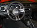 2012 Ford Mustang - The interior of a Ford Mustang features a leather-wrapped steering wheel and a modern dashboard layout.
