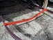 1993 Tracker Tournament - Close-up of a boat trailer's red painted frame and support brackets.