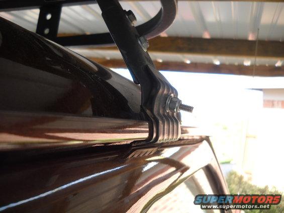 Close-up of a roof rack bracket on a shiny brown vehicle