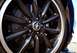 2012 Ford Mustang - Close-up of a black Ford Mustang wheel, red brake calipers and the iconic Mustang emblem.