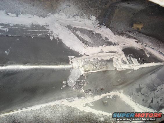 Underbody repair work with filler material applied to metal panels