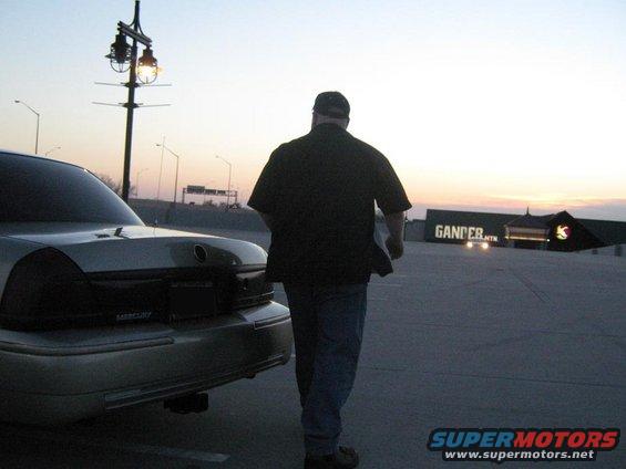 Rear of a 2000 Mercury Grand Marquis with a man walking away from it at dusk