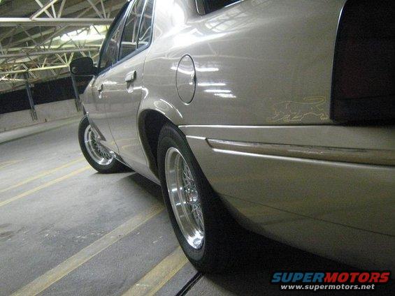 Gold Mercury Grand Marquis with wire wheels and a cougar emblem on the rear quarter panel