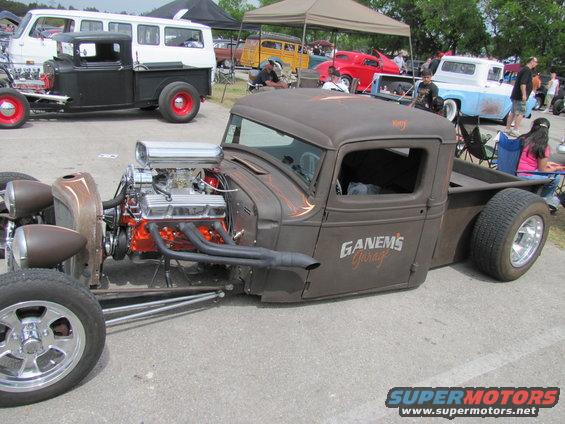 Custom hot rod pickup truck with exposed engine and "GANEMS Garage" lettering on door