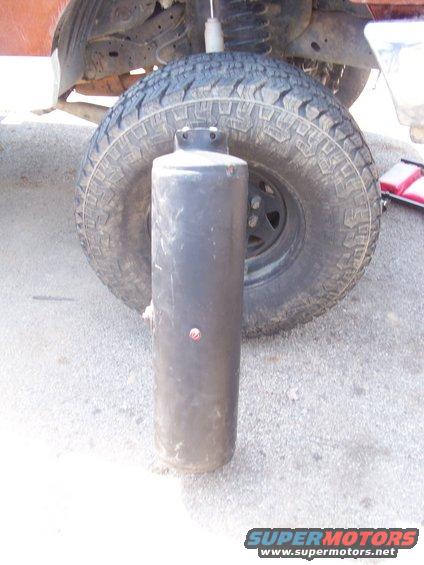 propane tank in front of a vehicle tire and suspension components