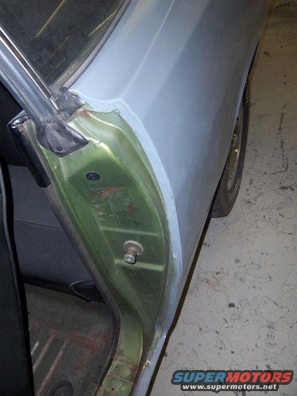 Car door jamb with green interior paint and gray primer exterior panel