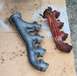 1976 Ford Ranchero - Two exhaust manifolds are shown, one appears to be a replacement part, the other is heavily rusted.