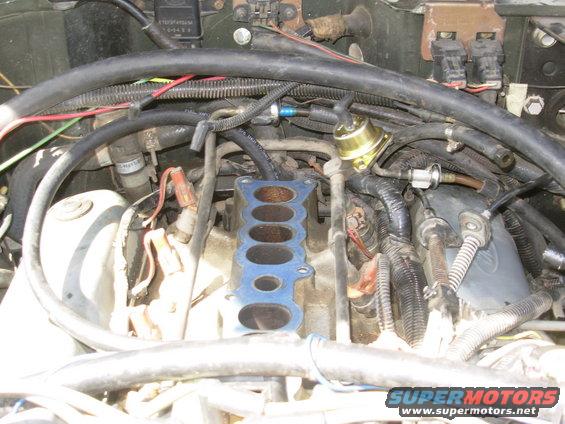pcvhosf.jpg As soon as the spark plug wire was fixed, the engine started surging, which eventually turned out to be a leaking FPR.  Big surprise - it was a 21-year-old junkyard part, but he still got his money's worth out of it.  So while I was changing it, I also replaced the PCV valve, hose, grommet, and fitting on the plenum.  I also replaced several other vacuum lines.
