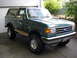 1990 Ford Bronco - 1990 Ford Bronco in a driveway, showing its front and side profile.