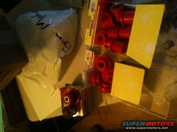 Red polyurethane bushings in packaging and a plastic bag, with yellow cards