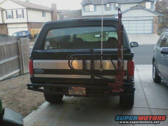 Black Ford Bronco rear view with a Hi-Lift jack mounted on the spare tire carrier