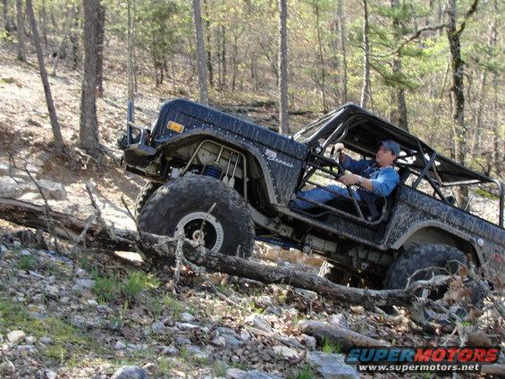Black Ford Bronco with roll cage navigating rocky terrain