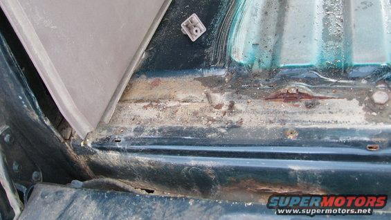 Dark green interior panel with significant rust and corrosion damage