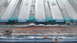 1992 Ford Bronco - Close-up of a rusted tailgate edge, with teal paint visible beneath the corrosion.