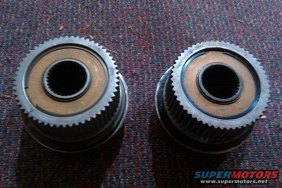 Two geared hubs with splined centers, sitting on a carpeted surface