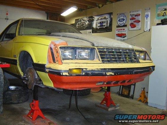 Yellow 1979 Ford Mustang front end on red jack stands, undergoing repairs