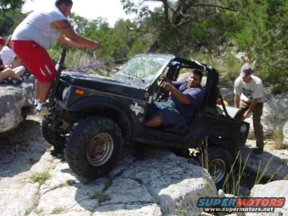 Black off-road vehicle with people on rocks