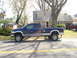 2005 Dodge 2500 - A blue Dodge Ram 2500 pickup truck is parked on the side of a residential street.