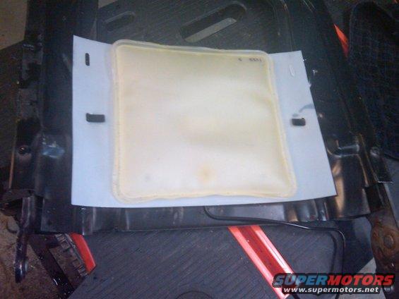 seat heater element on white paper, black seat frame visible