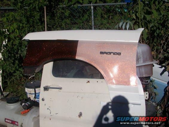 1989 Ford Bronco side panel with glitter paint and "Bronco" badge, next to a door