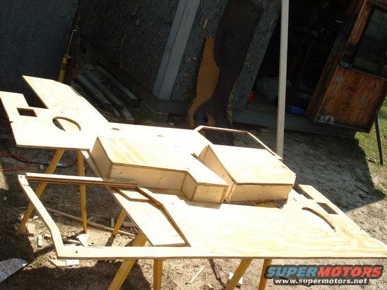 Wooden mock-up of a vehicle body on sawhorses outdoors
